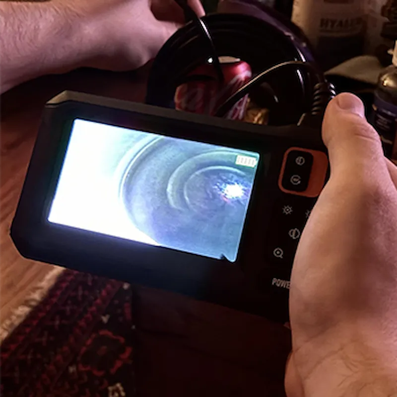 Frau prüft feuchte Stelle mit Kamera