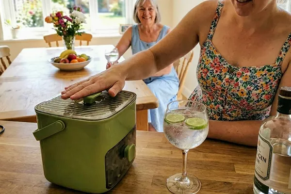 Vrouw drukt op de knop van de CubeNest en pakt ijs