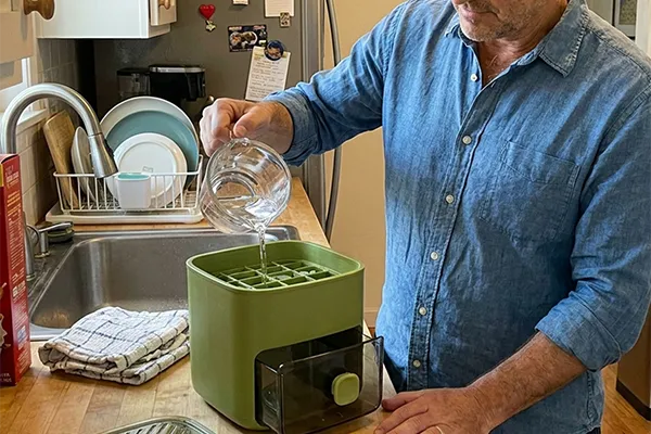 Man gebruikt de CubeNest voor een drankje in de keuken