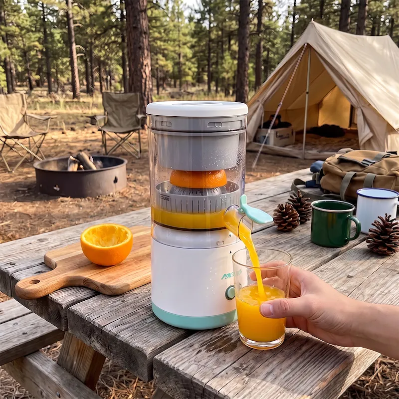 Vrouw perst vers sap met de CitroMax op de camping