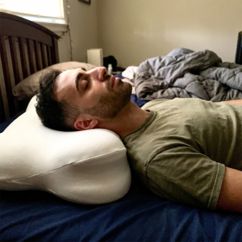 Man slaapt op CloudNest memory foam kussen op rug