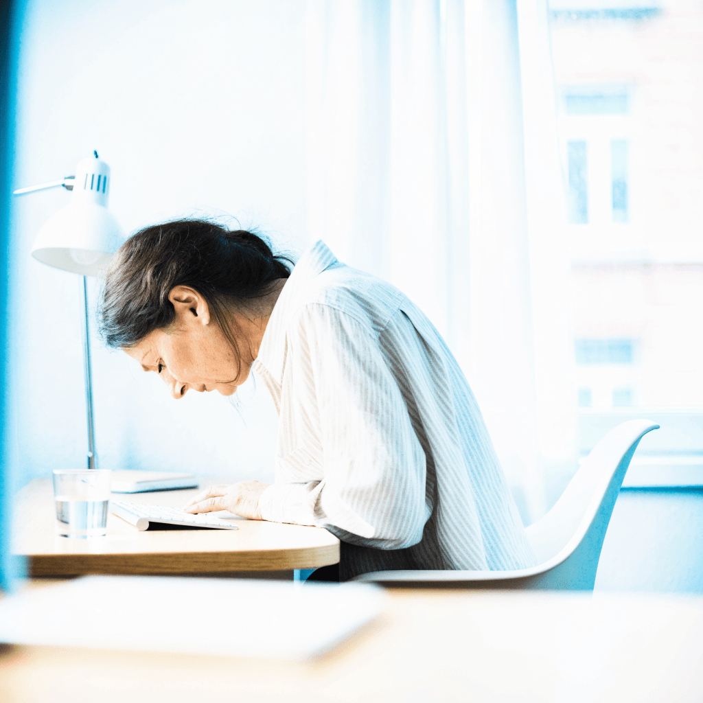 Vrouw zit ingezakt aan haar bureau